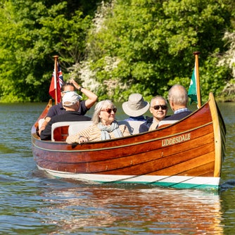 Visitors enjoying a boat ride on Liddesdale on the River Thames with Boating at Cliveden.